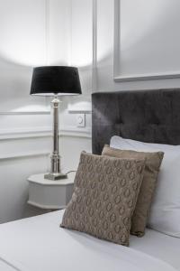 a bed with a pillow and a lamp on a table at Belle Boutique in Sliema
