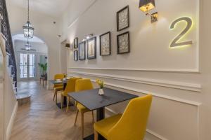a dining room with a table and yellow chairs at Belle Boutique in Sliema