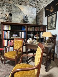 um quarto com uma mesa com cadeiras e estantes em La Maison Cayre, stylish house and terrace, Berlou, natural park em Berlou