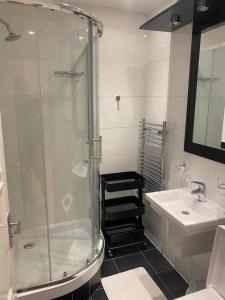 uma casa de banho com um chuveiro e um lavatório. em Cozy two bedroom flat in the heart of London em Londres