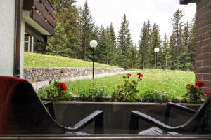a patio with two chairs and flowers in a yard at Rehwiesa in Arosa