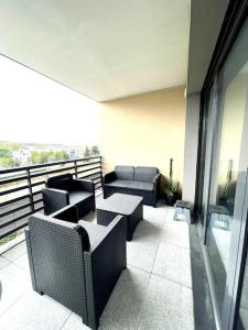 - un balcon avec des canapés et des chaises dans un bâtiment dans l'établissement Spacieux T2 + Parking à 5 min d'Aix, à Aix-en-Provence