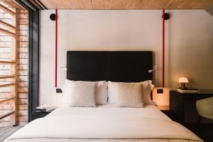 a bedroom with a white bed with a black headboard at Aethos Monterosa in Champoluc