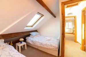 Schlafzimmer im Dachgeschoss mit 2 Betten und einem Fenster in der Unterkunft Oak Tree Cottage - Pendle - Forest of Bowland in Burnley