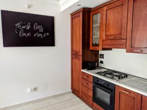 a kitchen with wooden cabinets and a black stove top oven at La casetta gialla in Rome