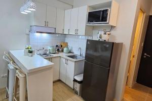 a kitchen with a black refrigerator and a sink at Steff's Condo 211 At Centrio in Cagayan de Oro