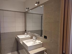 La salle de bains est pourvue de 2 lavabos et d'un miroir. dans l'établissement La casetta gialla, à Rome