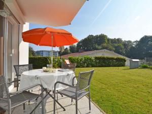 a table and chairs with an umbrella on a patio at Residenz Falkenberg - Apt. 03 in Ostseebad Sellin