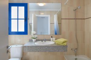 Un baño con lavabo, inodoro y espejo. en O Nautico Laxe, en Playa Blanca 17 fotos más