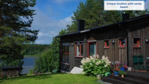 una casa con ventanas rojas y un lago en el fondo en The paradise by the beach 