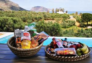 duas cestas de comida numa mesa ao lado de uma piscina em Manifesto Suites em Monemvasia