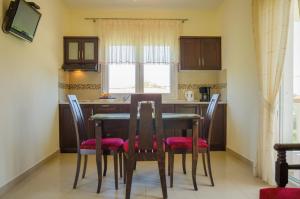 eine Küche mit einem Tisch und Stühlen im Zimmer in der Unterkunft San Giorgio Apartments in Skala Potamias