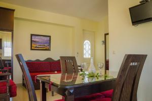 ein Wohnzimmer mit einem Tisch und einem roten Sofa in der Unterkunft San Giorgio Apartments in Skala Potamias