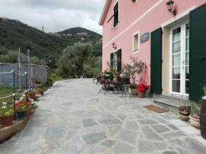 a patio of a pink building with tables and chairs at L'antico Frantoio dei nonni in Sestri Levante