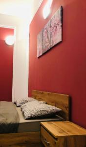a bedroom with a bed and a red wall at Nights bucharest apartment oldtown in Bucharest