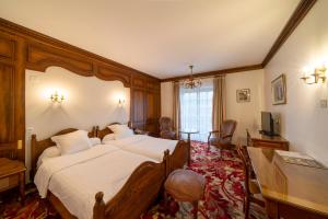 a hotel room with two beds and a television at Hotel Munsch Restaurant & Wellness, Colmar Nord - Haut-Koenigsbourg in Saint-Hippolyte +91 photos