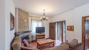 - un salon avec un canapé et une télévision dans l'établissement Cortijo Sylvestris Periana by Ruralidays, à Periana