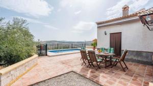 une terrasse avec une table, des chaises et une piscine dans l'établissement Cortijo Sylvestris Periana by Ruralidays, à Periana