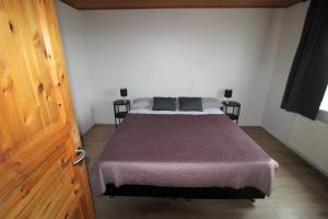 1 dormitorio con 1 cama con manta morada en Húsavík Apartments en Húsavík