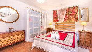 ein Schlafzimmer mit einem Bett, zwei Kommoden und einem Spiegel in der Unterkunft Cortijo El Nuevo Olivo Órgiva by Ruralidays in Órgiva