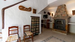 sala de estar con chimenea y 2 sillas en El Molinillo de Jimera Jimera de Libar by Ruralidays, en Jimera de Líbar