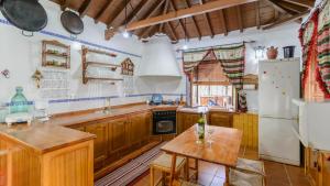 a kitchen with wooden cabinets and a white refrigerator at La Guitarra Andaluza Loja by Ruralidays in Loja