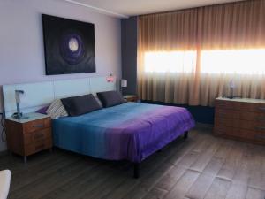 ベナルマデナにあるAtico De Lujo Vistas Al Marのベッドルーム(青いベッド1台、窓付)