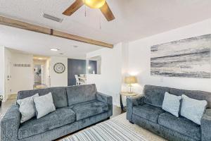 a living room with two couches and a ceiling fan at Dog-friendly home with fenced yard, patio, grill, & park across the street in Saint Augustine