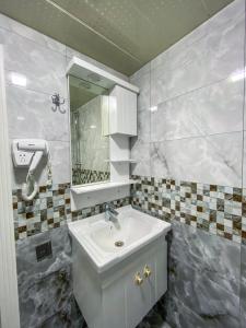 uma casa de banho com um lavatório e um espelho em Miramida Hotel em Zaqatala