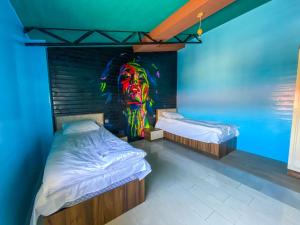 um quarto com duas camas e uma pintura de uma cabeça em Miramida Hotel em Zaqatala