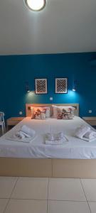 ネア・ペラモスにあるILIDA apartmentsの青い壁のベッドルーム1室(大型ベッド1台付)