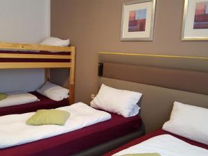 Zimmer mit 2 Etagenbetten mit weißer Bettwäsche in der Unterkunft Gasthof Alte Schule in Fürstenzell