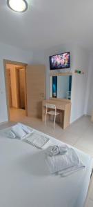 1 dormitorio con 1 cama, escritorio y TV en ILIDA apartments, en Nea Peramos