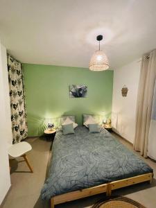 een slaapkamer met een bed en een groene muur bij Cottage Dune in Saint-Jean-de-Monts