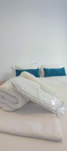 einen Stapel weißer Handtücher auf einem Bett in der Unterkunft ILIDA apartments in Néa Péramos