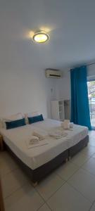 a large bed in a room with a blue curtain at ILIDA apartments in Nea Peramos