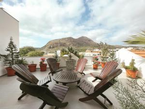 een patio met een tafel en stoelen en een berg bij Hotel Viajante in Tarrafal