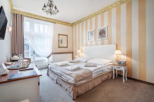 a bedroom with a bed and a desk in it at Małopolanka & Spa in Krynica Zdrój