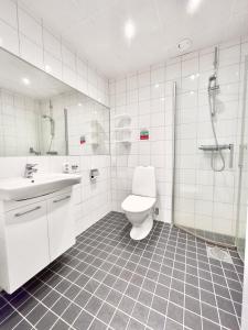 uma casa de banho com um WC, um chuveiro e um lavatório. em Kostergården em Sydkoster