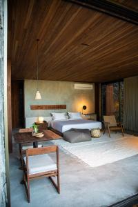 a bedroom with a large bed and a table at Paru Boutique Hotel in São Miguel dos Milagres