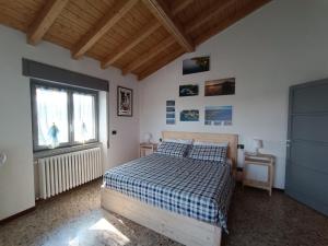 a bedroom with a bed with a checkered blanket and a window at Casa Le Fornaci in Ispra