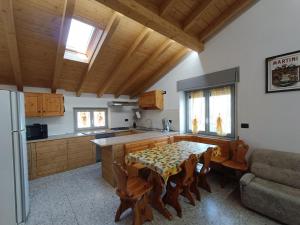 eine Küche mit einem Tisch, Stühlen und einer Theke in der Unterkunft Casa Le Fornaci in Ispra