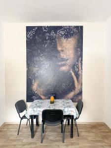 JP ubytování Loštice في Loštice: غرفة طعام مع طاولة و لوحة على الحائط