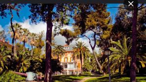 een groot huis met palmbomen ervoor bij Marine Sea View in Sanremo