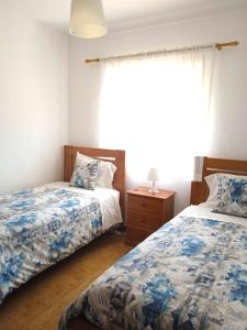 a bedroom with two beds and a window at Baleal Sol Alojamentos in Baleal