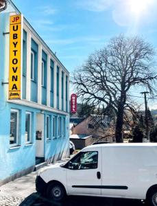 una furgoneta blanca estacionada frente a un edificio en JP ubytování Loštice, en Loštice