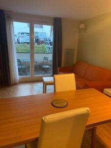 a living room with a wooden table and chairs at Le Nivelet Les balcons d'Aix in La Féclaz