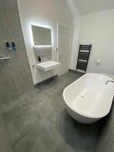 a bathroom with a large white tub and a sink at New purpose built holiday lodge in Scorton