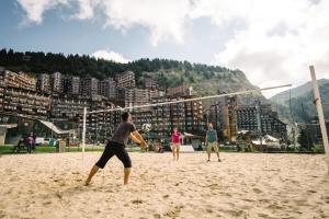 Belambra Clubs Avoriaz - Les Cimes du Soleil في أفورياز: مجموعة من الناس يلعبون كرة الطائرة على الشاطئ