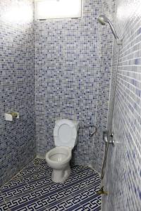 y baño con aseo y azulejos azules. en Tafoukt house ,tamraght, en Aourir